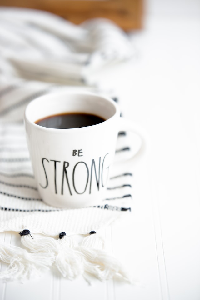 "Be Strong" written on a coffee mug.